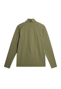 Långärmad olivgrön topp med hög krage. Har en texturerad tyg med diagonala mönster och raglanärmar.