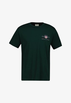 Sötétzöld, pamut póló, kerek nyakkivágással. Piros és fehér csíkos logóval és "GANT American Sportswear" felirattal rendelkezik.