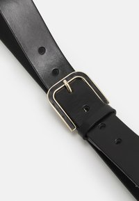 Cinturón de cuero negro con hebilla rectangular de metal en tono dorado. Incluye múltiples agujeros para ajuste. Textura suave con un diseño elegante.