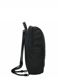 Zaino nero realizzato in tessuto testurizzato, con una tasca laterale e spallacci lisci. Chiusura a zip sulla parte superiore con una forma leggermente arrotondata.