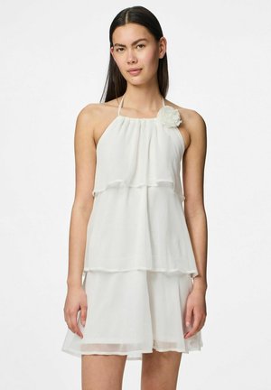 Vestido halter blanco hecho de tela ligera con capas en cascada y un acento floral en el pecho. Textura suave y diseño fluido.