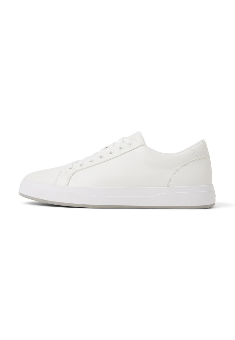 Zapatilla blanca hecha de cuero sintético liso con punta redonda, suela blanca plana, seis ojetes y un diseño minimalista.