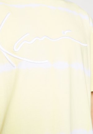 Lichtgele T-shirt met witte horizontale strepen en geborduurde cursieve tekst. Zachte katoenen stof met een gladde textuur.