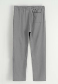 Pantalons gris à jambes droites avec taille élastique et une poche arrière plaquée, posés à plat sur un fond blanc.