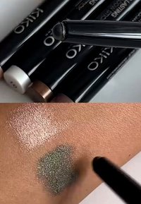 KIKO øjenskyggepenne i sort etui med farvede låg. Prøver på huden viser skinnende rosa og mørkegrøn med metallisk glans.