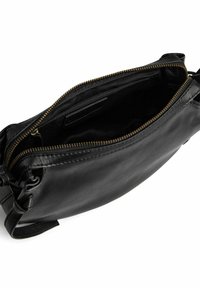 Borsa in pelle nera con chiusura a zip, caratterizzata da una texture liscia e una zip in tono oro. L'interno è foderato in tessuto nero, mostrando un design aperto.