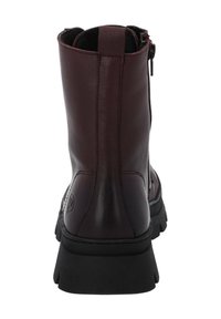 Botín de cuero burdeos con un acabado suave, punta redonda y suela de goma negra contrastante. Incluye un cierre con cremallera en el costado.
