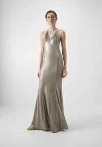 Metallic silver mekko, jossa on halterneck-olkaimet, istuva siluetti, virtaava hame ja sileä pinta. Sisältää drapeerauskoristeita helmassa.