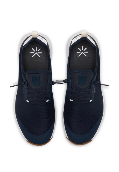 Námořnické modré sportovní boty s síťovaným svrškem, elastickými šňůrkami a bílými akcenty na jazyku a mezi podešví. Texturovaný vzor na povrchu boty.