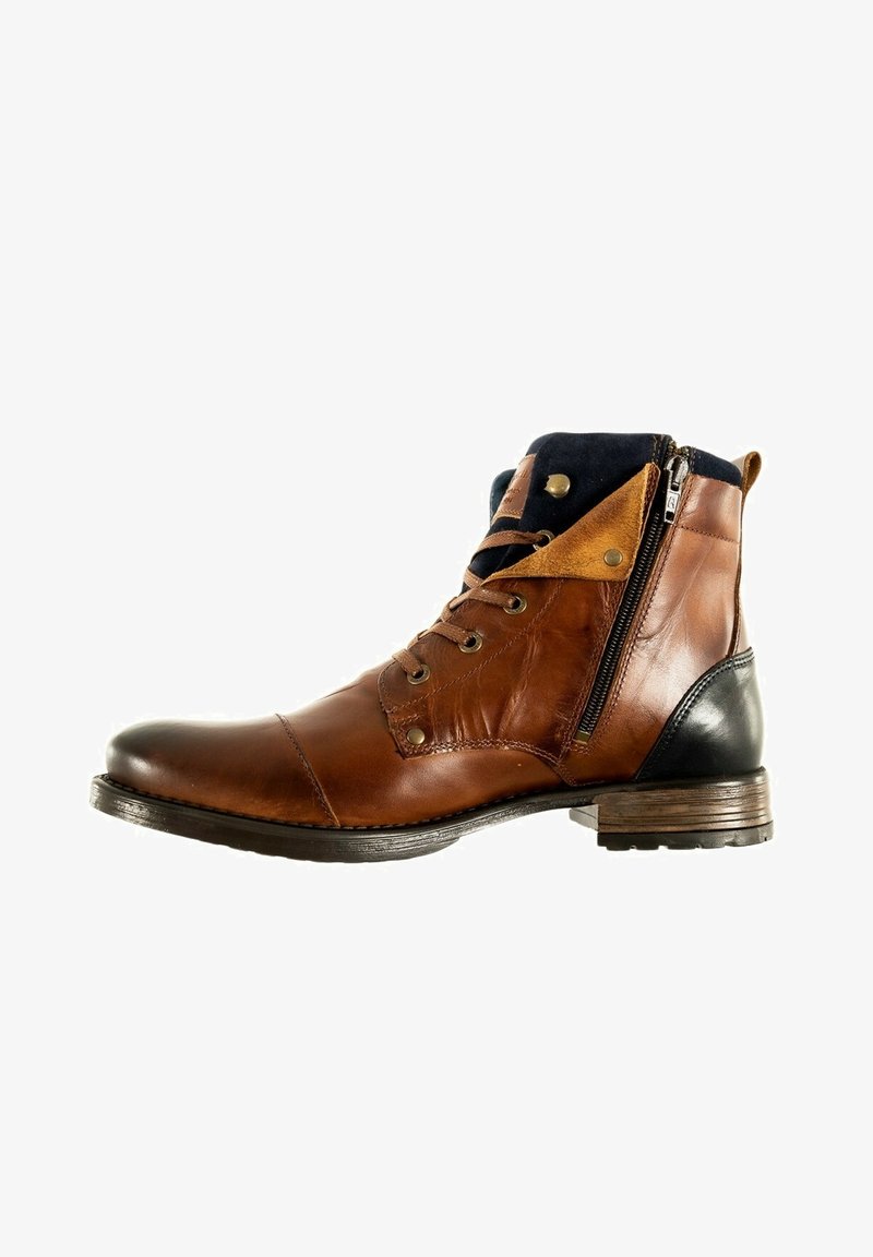 Bruine leren enkelboot met zwarte hak, voorzien van zilverkleurige hardware, een zijrits, tan accenten en structuurpanelen op de bovenkant.