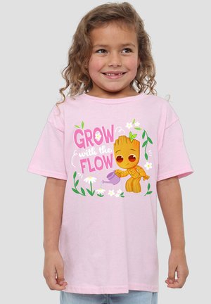 Rosa Baumwoll-T-Shirt mit einem Comic-Charakter, der Blumen gießt, und dem Text "GROW with the FLOW" in verspielter Typografie und grünen Akzenten.