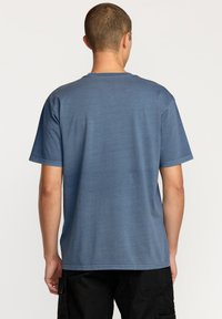Blå kortærmet t-shirt med rund hals, lavet af blødt stof. Bagsiden har en glat tekstur og en afslappet pasform.
