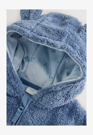 Kék bolyhos kapucnis dzseki, puha külső textúrával és világoskék béleléssel, amelyen kis mancsminták találhatók. A kapucnin fül részletek is találhatók.