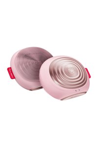 Rosa ansiktsrengöringsapparat med texturerade silikonborstar på ena sidan och en slät, präglad yta på baksidan. Har en logotyp och knappar.