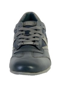 Zapatilla de cuero gris con punta redondeada, cordones grises y acentos de textil. Presenta un acabado suave, suela de goma plana y una marca sutil.