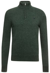 Maglione a coste in verde scuro con maniche lunghe, colletto alto a zip parziale e un piccolo logo ricamato sul lato sinistro del petto.