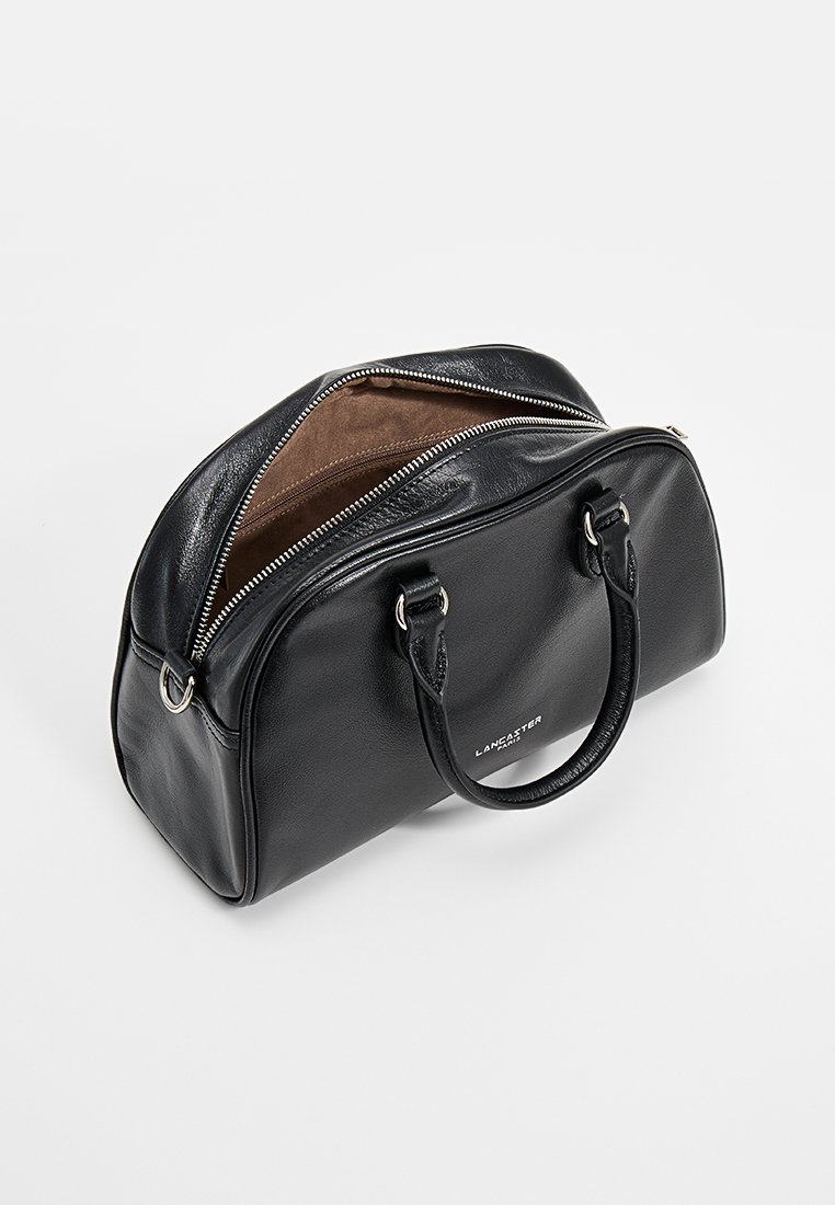 Schwarze Lederhandtasche mit einem Reißverschluss, zwei Griffen und einem beigen Innenfutter. Besitzt eine abgerundete Form und silberne Hardware-Akzente.