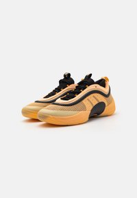 Sneakers con una combinazione di colori giallo e nero, tomaia in mesh, suola spessa, design testurizzato e dettagli a contrasto lungo i lati.