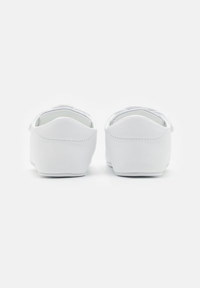 Hvite skinn slip-on sko med en glatt tekstur, rund tå og subtil søm detaljer ved hælen.