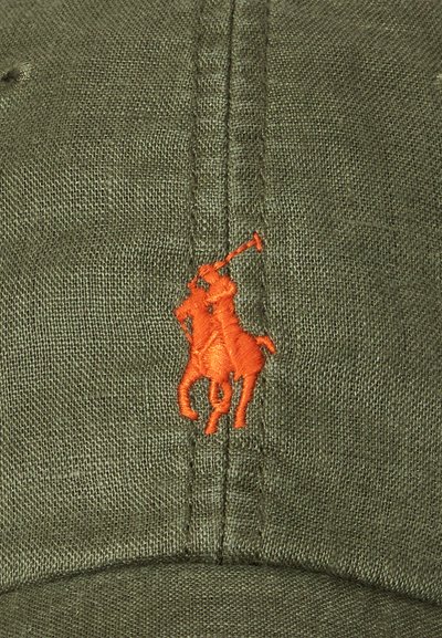 Khaki cap made of textured fabric, featuring an orange embroidered polo player logo on the front. Visor is curved with visible stitching.