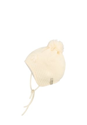 Cream-colored knitted baby hat with ear flaps, tie strings, pom-pom on top, and small flower detail on the side.