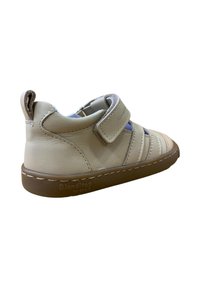 Zapatos de cuero beige para niños pequeños con tira de velcro, acentos en azul claro y suela de goma texturizada. Cuentan con una punta redondeada y un diseño fácil de poner.