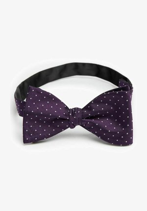 Lila fluga med vita prickar, tillverkad av strukturerad tyg. Justerbar rem med en slät svart innerfoder. Klassisk form.