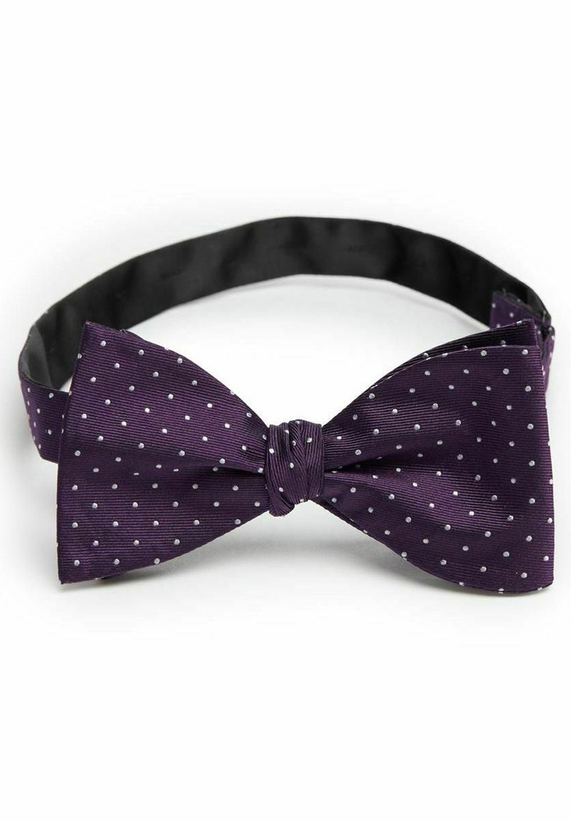 Lila fluga med vita prickar, tillverkad av strukturerad tyg. Justerbar rem med en slät svart innerfoder. Klassisk form.