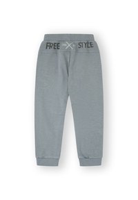 Pantalones de chándal de algodón gris con una cinturilla acanalada que presenta el texto "FREE" y "STYLE" en negro. Puños en los tobillos. Textura suave.