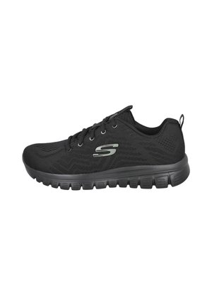 Zapatilla deportiva negra Skechers con parte superior de malla, cierre de cordones en la parte delantera, suela gruesa y acolchada, y logotipo gris de Skechers en el lateral.