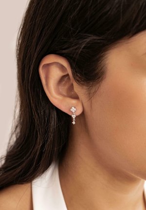 Silberne hängende Ohrringe mit mehreren diamantförmigen Kristallen in unterschiedlichen Größen; zeigen aufwendige Details und eine polierte Oberfläche.