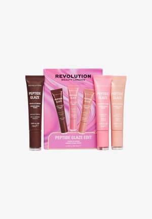 Trois tubes de sérum teinté pour les lèvres Revolution Beauty Peptide Glaze en nuances rose et marron avec la boîte du produit en arrière-plan.