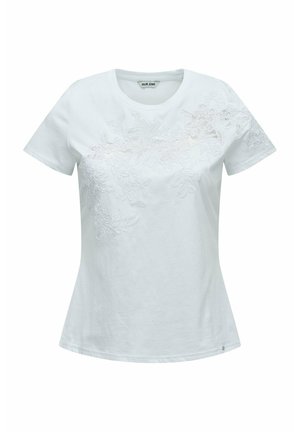 T-shirt blanc à manches courtes pour femme, col rond, avec une broderie florale subtile sur la poitrine et le haut côté droit.