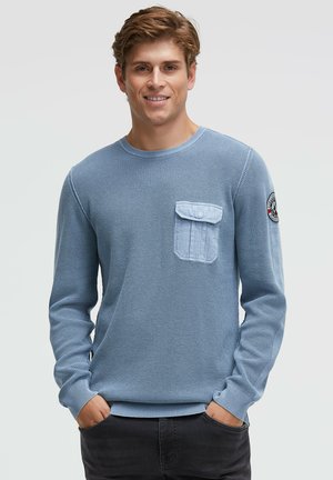 Hellblauer langärmliger Strickpullover mit strukturiertem Stoff, rundem Ausschnitt und einer Brusttasche in kontrastierendem Hellblau.