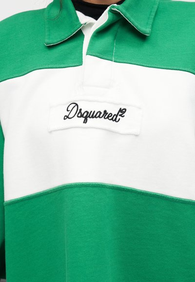 Πράσινο και λευκό πουκάμισο με γιακά, με το λογότυπο "Dsquared²" κεντημένο με μαύρα γράμματα σε λευκή ετικέτα στο στήθος.