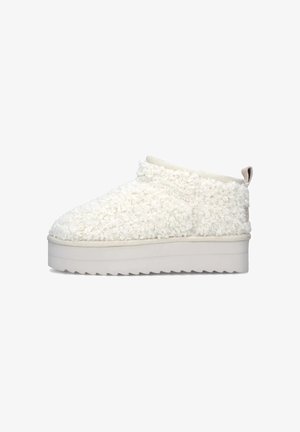 Scarpa bianca in tessuto morbido, slip-on con parte superiore testurizzata, suola platform bianca elevata e un piccolo loop sul retro per facilitare l'indossamento.