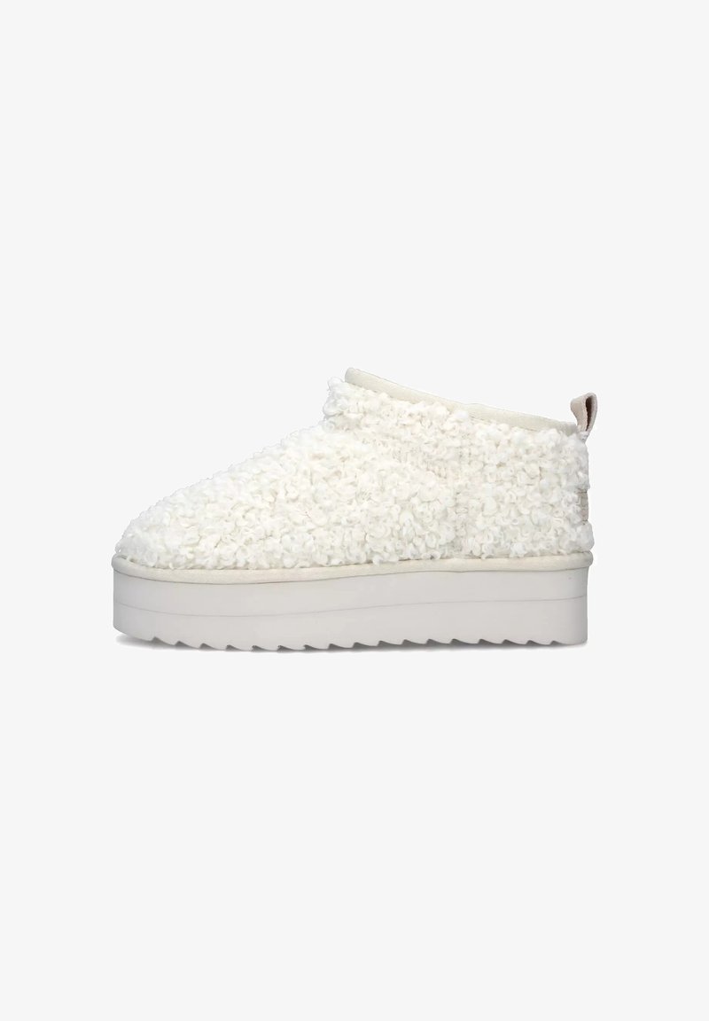 Scarpa bianca in tessuto morbido, slip-on con parte superiore testurizzata, suola platform bianca elevata e un piccolo loop sul retro per facilitare l'indossamento.