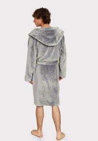 Gray hooded bathrobe made of soft, plush fabric, featuring long sleeves, a tie belt, and an adjustable hood. Bare feet visible.