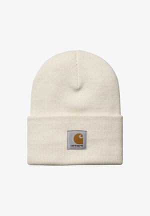 Gorro de punto color crema con vuelta, que presenta un parche cuadrado con logotipo en mostaza y gris.