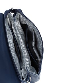 Námorně modrá kožená kabelka se zipem nahoře. Uvnitř má tři přihrádky s podšívkou se zigzag vzorem. Stříbrné kovové doplňky.