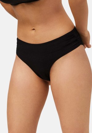 Braga de algodón negra con textura suave y una cintura con un delicado borde de picot. El diseño ofrece un estilo de cobertura clásica.