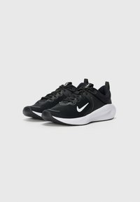 Black athletic shoes with mesh upper, white swoosh logo, cushioned sole, and laces. Features heel pull tab for easy wear.