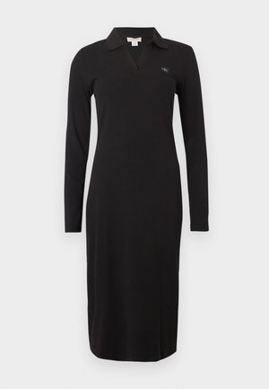Czarna sukienka z długim rękawem i kołnierzykiem, z dekoltem w serek i dopasowanym krojem. Materiał ma prążkowaną teksturę. Zawiera małe logo.