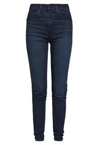 Tmavě modré skinny džíny s vysokým pasem, s předním knoflíkem a kapsami, navržené pro štíhlý střih přes nohy až k kotníkům.