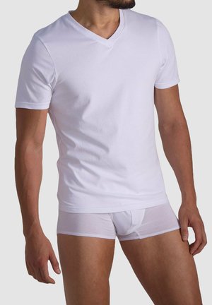 Weißes kurzärmliges V-Ausschnitt-T-Shirt aus weicher Baumwolle, kombiniert mit weißen, enganliegenden Slips, die eine glatte Textur und ein minimalistisches Design zeigen.