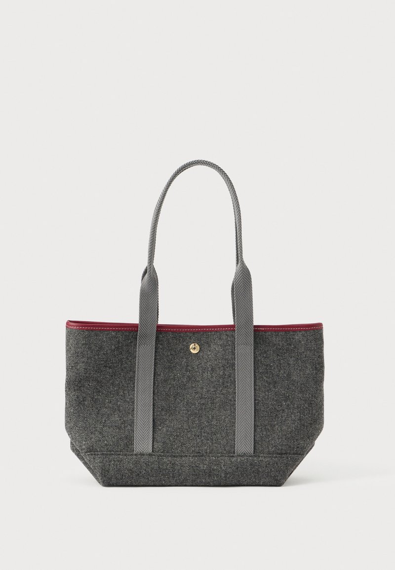 Γκρίζα τσάντα tote με μακριές γκρίζες λαβές, μπορντό περιθώριο στην κορυφή και ένα μικρό χρυσό κούμπωμα σε λευκό φόντο.