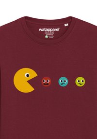 T-shirt bordeaux avec un graphique de Pac-Man jaune et quatre icônes de personnages colorés affichant diverses expressions faciales imprimées sur le devant.