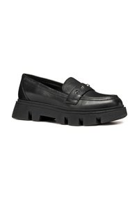 Mocasines de cuero negro con punta redondeada, que presentan una correa decorativa y tachuelas, además de una suela de goma gruesa con detalles estriados.