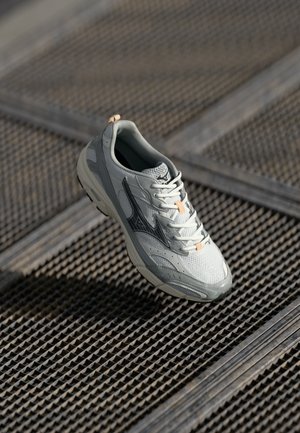 Light gray athletic shoe with mesh upper, rubber sole, orange accents, and black logo detail. Features rounded toe and lace-up design.