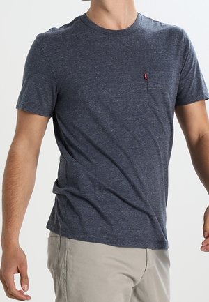 Herren T-Shirt in Marineblau mit kurzen Ärmeln aus einer Baumwollmischung, runder Halsausschnitt und kleiner Brusttasche mit rotem Tab.